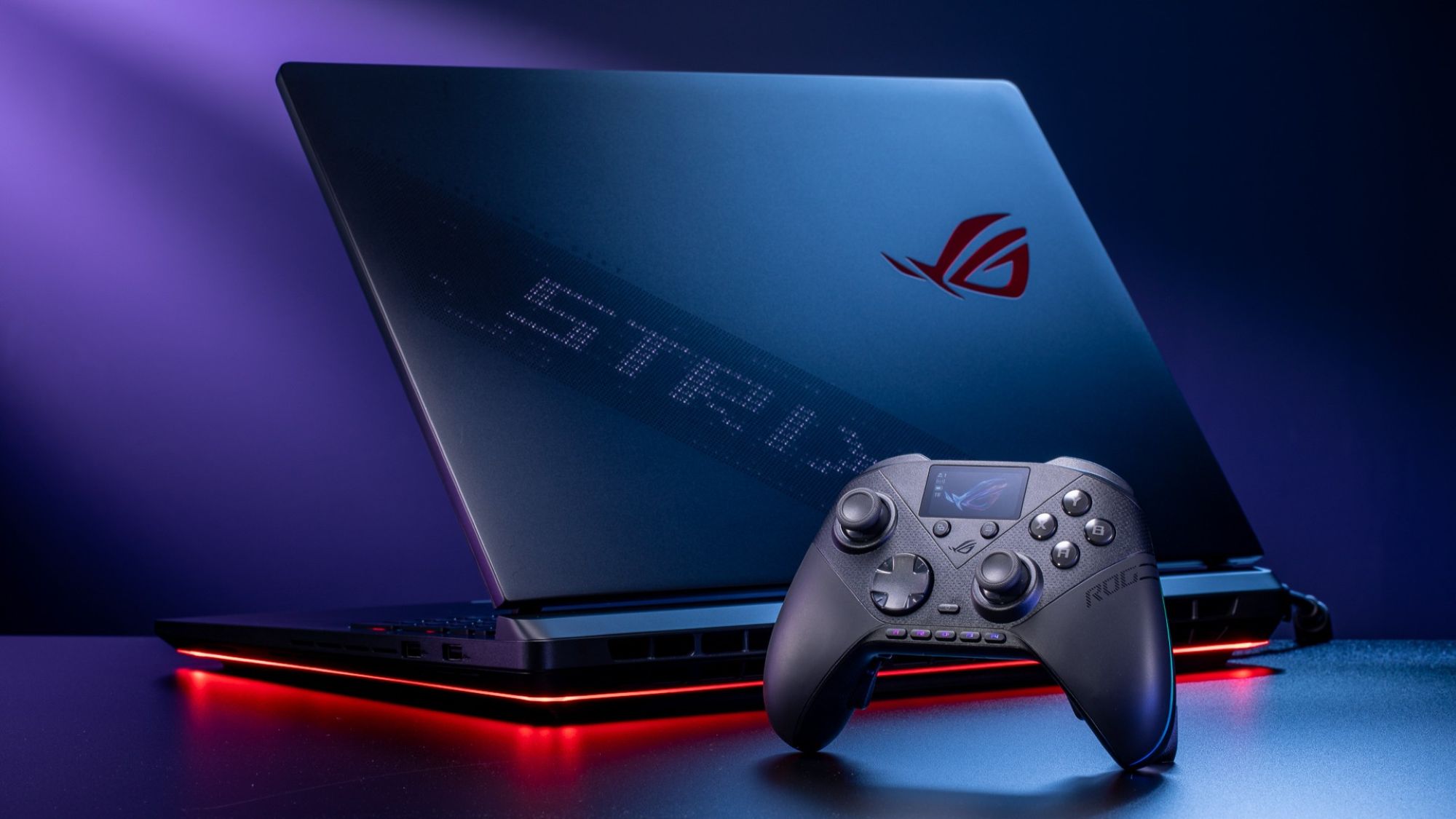 The ROG Raikiri II Pro PC Controller beside an ROG Strix laptop on a black table.