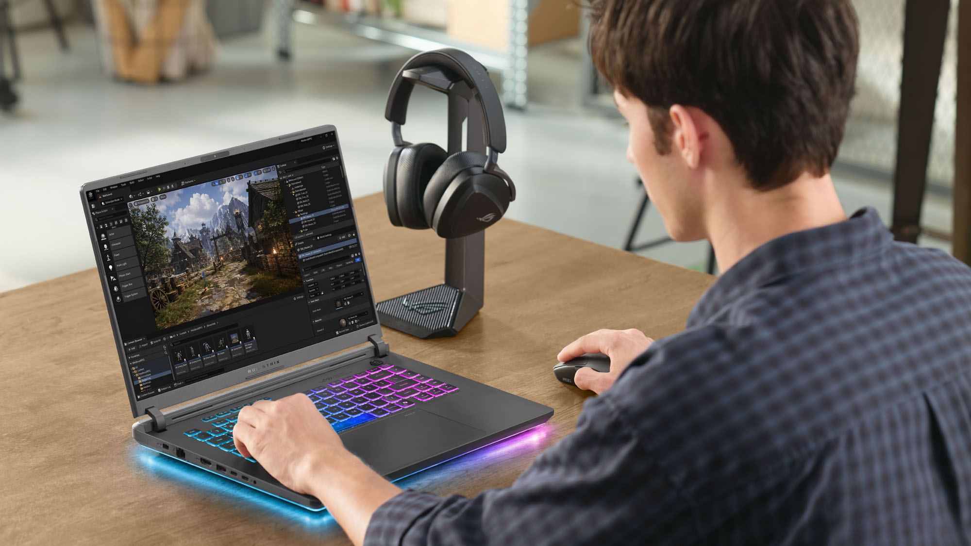 A man doing game development on an ROG Strix G16 laptop